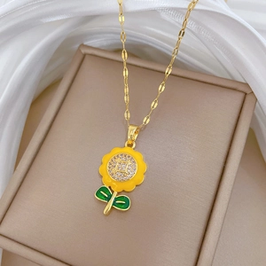 Detailed view of sunflower pendant with yellow petals and inlaid sparkling crystals on gold chain