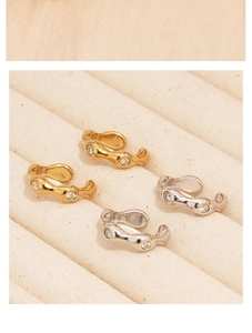 Detail view of wavy textured ear cuffs in gold and silver finish with zircon stones