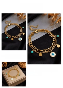 Detailed view of gold double-layer chain bracelet featuring turquoise and evil eye charms