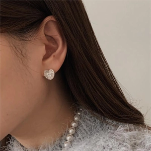 Detailed close-up of 925 sterling silver heart stud earrings with wrinkled metal texture