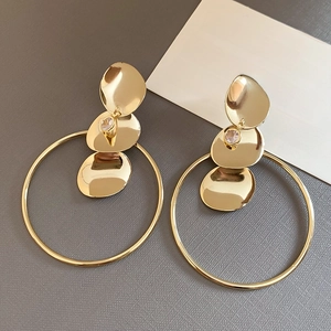 Detailansicht der dreischichtigen goldenen ovalen Plättchen und großen hängenden Ohrringe