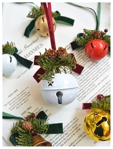 Christmas metal bells with velvet ribbons, pine cones and needles for festive decor