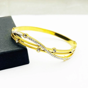 Eleganter goldener Lagen-Armreif mit Zirkonia-Steinen und schwarzer Schmuckschatulle