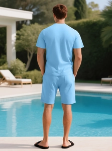 Men's sky blue waffle knit set featuring short sleeves and shorts near a luxury pool