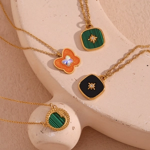 Detail of 18K gold plated heart and square pendants on plaster display stand