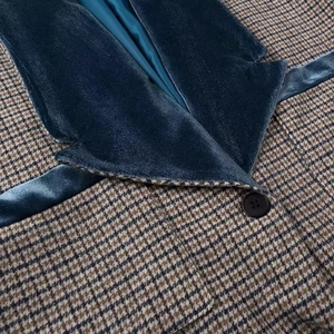 Détail de la veste à carreaux avec col en velours bleu foncé et tissu motif pied-de-poule