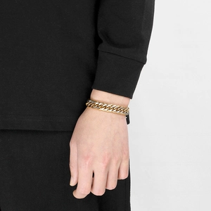 Gros plan d'un bracelet gourmette bicolore or et argent montrant la texture du métal brossé