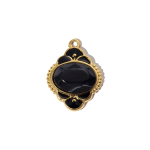 Macro detail of gold-framed black oval pendant with vintage embossed textures