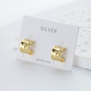 Detail view of gold-plated 925 sterling silver C-shape earrings on white card display