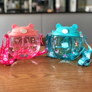 Close-up of pink and blue donut-shaped kids straw cups with printed shoulder straps
