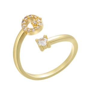 Macro detail of gold-plated open ring featuring a micro-paved letter G and a round solitaire