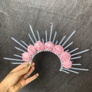 Detail of pink satin roses and golden halo zip ties on creative gothic headband
