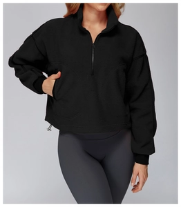Detail of black fleece sweatshirt featuring adjustable drawstring hem and ribbed cuffs