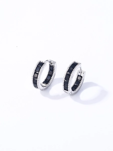 Detalle de pendientes de aro plateados con circonitas negras y bordes con relieve