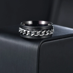 Detail of a rotating black stainless steel spinner ring with inlaid silver Cuban link