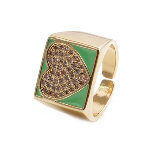 Macro detail of wide gold ring with green enamel inlay and sparkling crystal heart