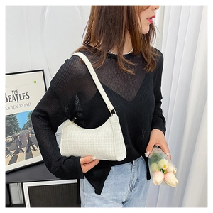Détail du sac à bandoulière en tweed blanc avec fermeture éclair en métal et tissu tissé