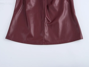 Close-up of wine red PU leather hem showing glossy texture and refined stitching detail