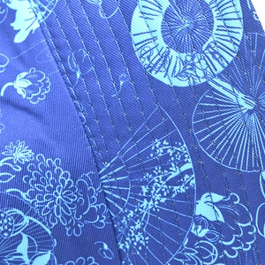 Detailed macro shot of blue fabric sun hat with floral pattern and fine parallel stitching