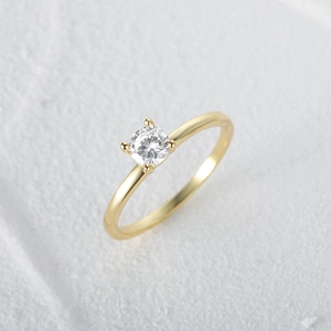 Macro shot of a luxury round cut diamond ring with gold band and classic four-prong setting