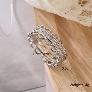 Close-up of silver geometric open ring with hollow lace design and clear zircon stones