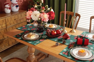 Close-up of green festive table runner and mats with snowflake and holiday patterns