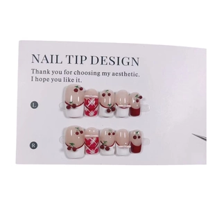 Handmade Christmas press-on nails featuring 3D red cherries and plaid bow designs