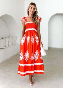 Détail d'une robe longue imprimée bohème rouge et blanche avec bretelles à volants