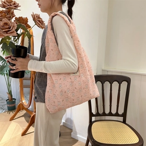 Pink quilted bubble fabric tote bag with cute rabbit print worn on a model shoulder