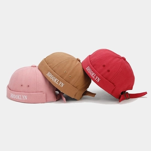Detailed view of pink, camel and red cotton Miki hats with Brooklyn letter embroidery