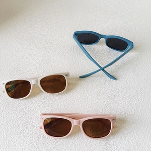Three pairs of vintage matte kids sunglasses in blue, beige, and pink colors with UV400 lenses