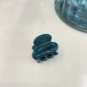 Detail of dark green handmade acetate hair claw clip with golden France lettering