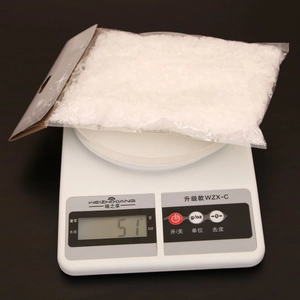 Detailed view of 51g artificial Christmas snow powder in clear packaging on a digital scale