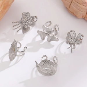 Macro shot of silver stainless steel leaf and floral patterned adjustable open rings
