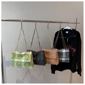 Detail of minimalist chain square bags in tweed and woven textures on hangers