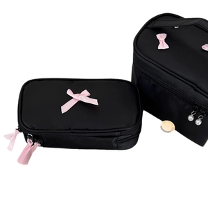 Black nylon cosmetic bags with pink bow decor and pearl zipper pulls for travel