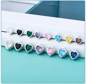 Macro shot of colorful heart zircon pendants in S925 silver settings on white steps