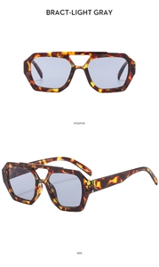 Detail view of tortoiseshell aviator sunglasses with hollow double bridge and light gray lenses