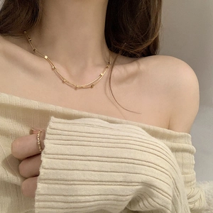 Double-layered gold titanium steel necklace with square pendants on a female model
