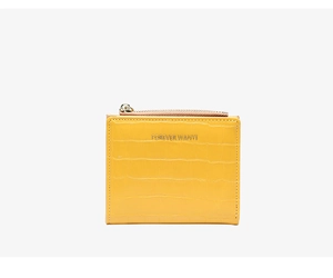 Close-up of yellow slim wallet featuring crocodile texture and gold lettering