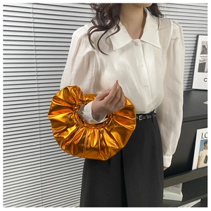 Detaillierte Ansicht der metallisch orangefarbenen Plissee-Wolkenhandtasche mit Ringgriff