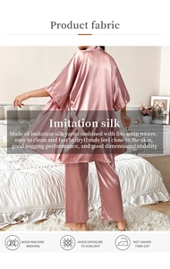 Detail of pink faux silk pajama set showing smooth satin fabric and belted kimono robe