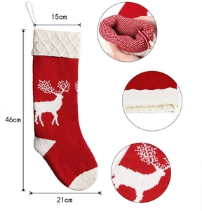Detailed view of red knitted Christmas stocking with reindeer pattern and size dimensions