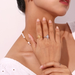 Detailed view of irregular textured rings and freshwater pearl necklace on a model