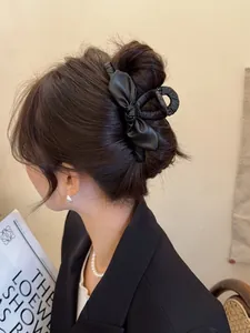 Elegante pinza per capelli a fiocco in pelle nera indossata per uno stile raffinato