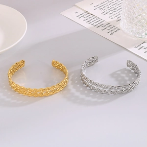 Detail of twisted cable cuff bracelets in gold and silver finish with spiral texture