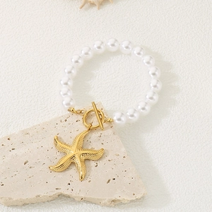Vue détaillée du pendentif étoile de mer dorée sur bracelet perles et fermoir OT