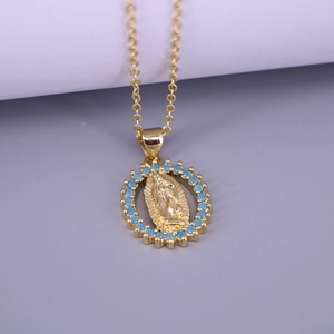 Detail of gold Virgin Mary oval pendant necklace with blue stones on a minimalist background