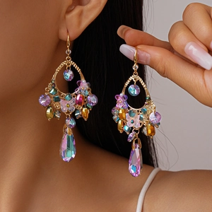 Detail of vintage gold drop earrings with butterfly motif and colorful crystals
