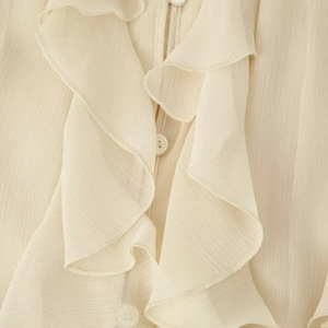 Blouse élégante en mousseline beige avec col en V, volants superposés et boutons